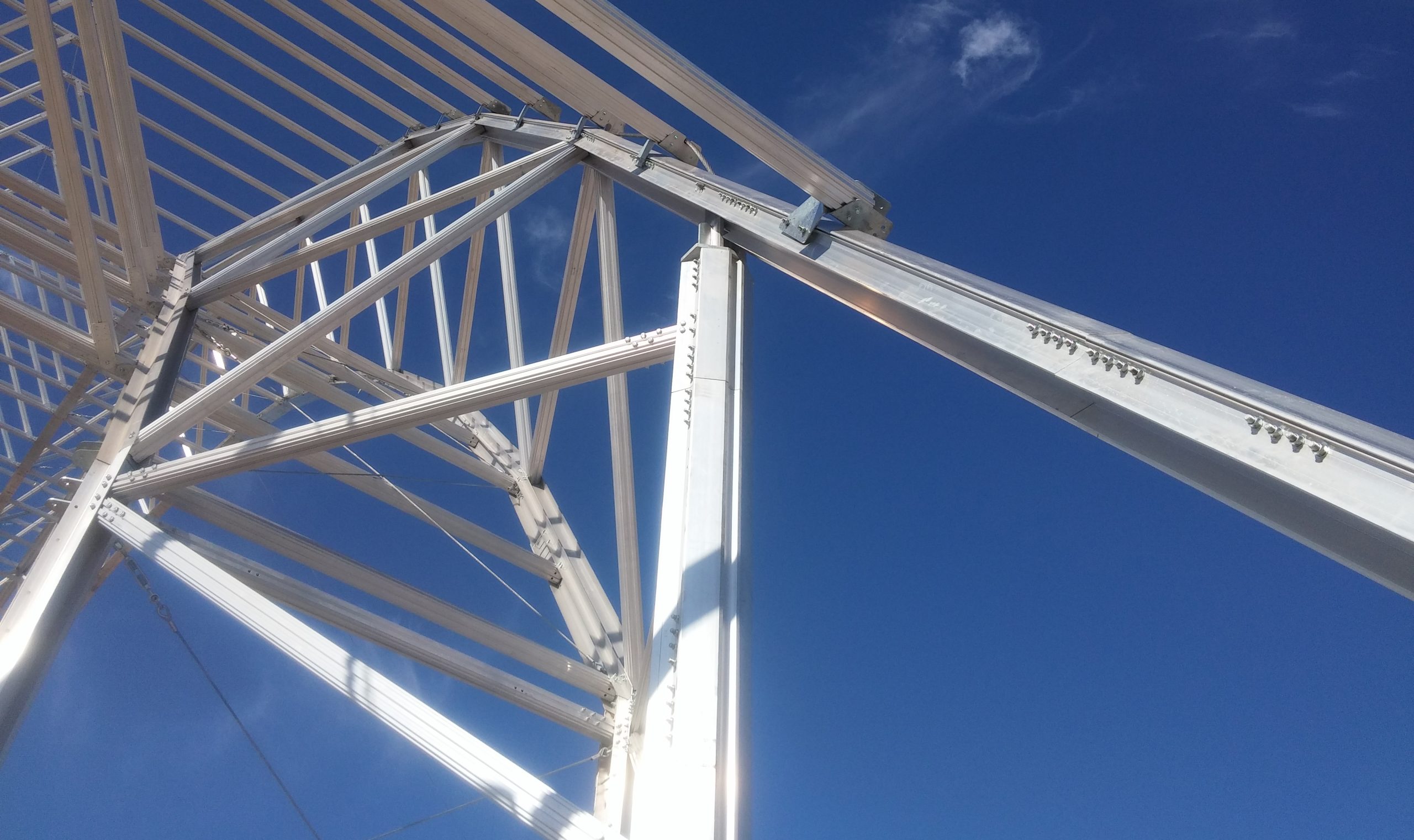Aluminum truss structure from the Gaptek building system with bolted joints, viewed from below during the assembly of a hangar